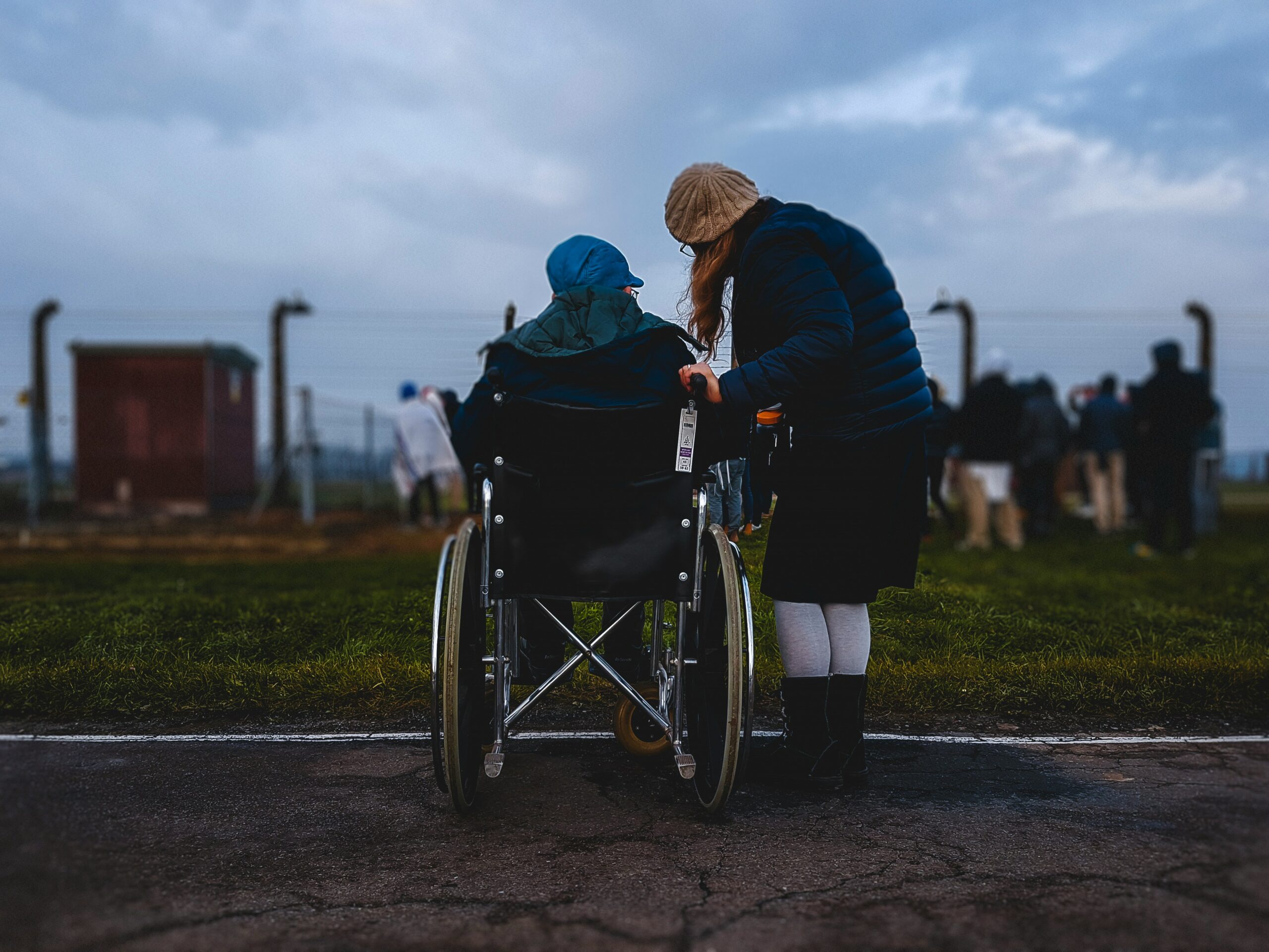 Woman standing near person in wheelchair