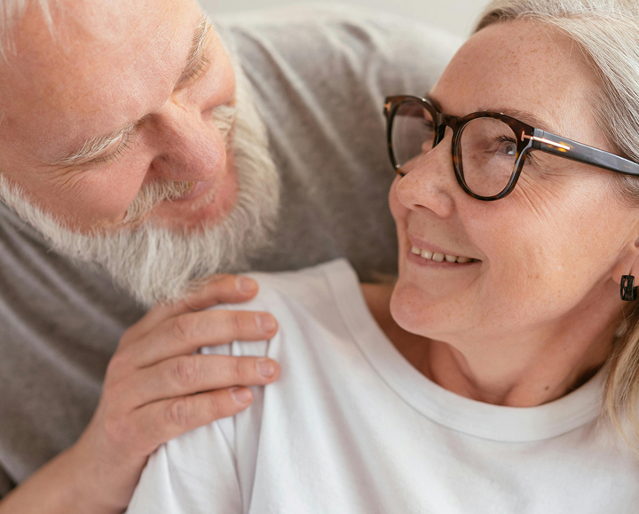 elderly couple looking at each other smiling